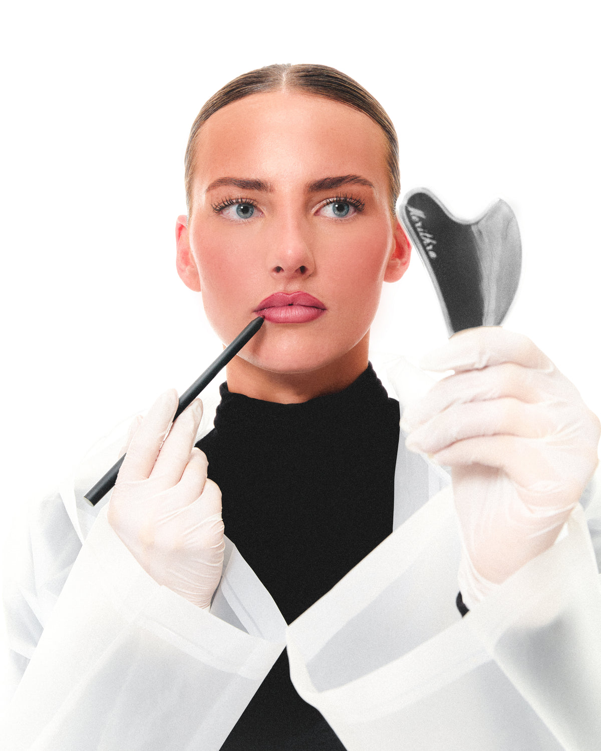 Model in a lab coat with the lip pencil and gua sha