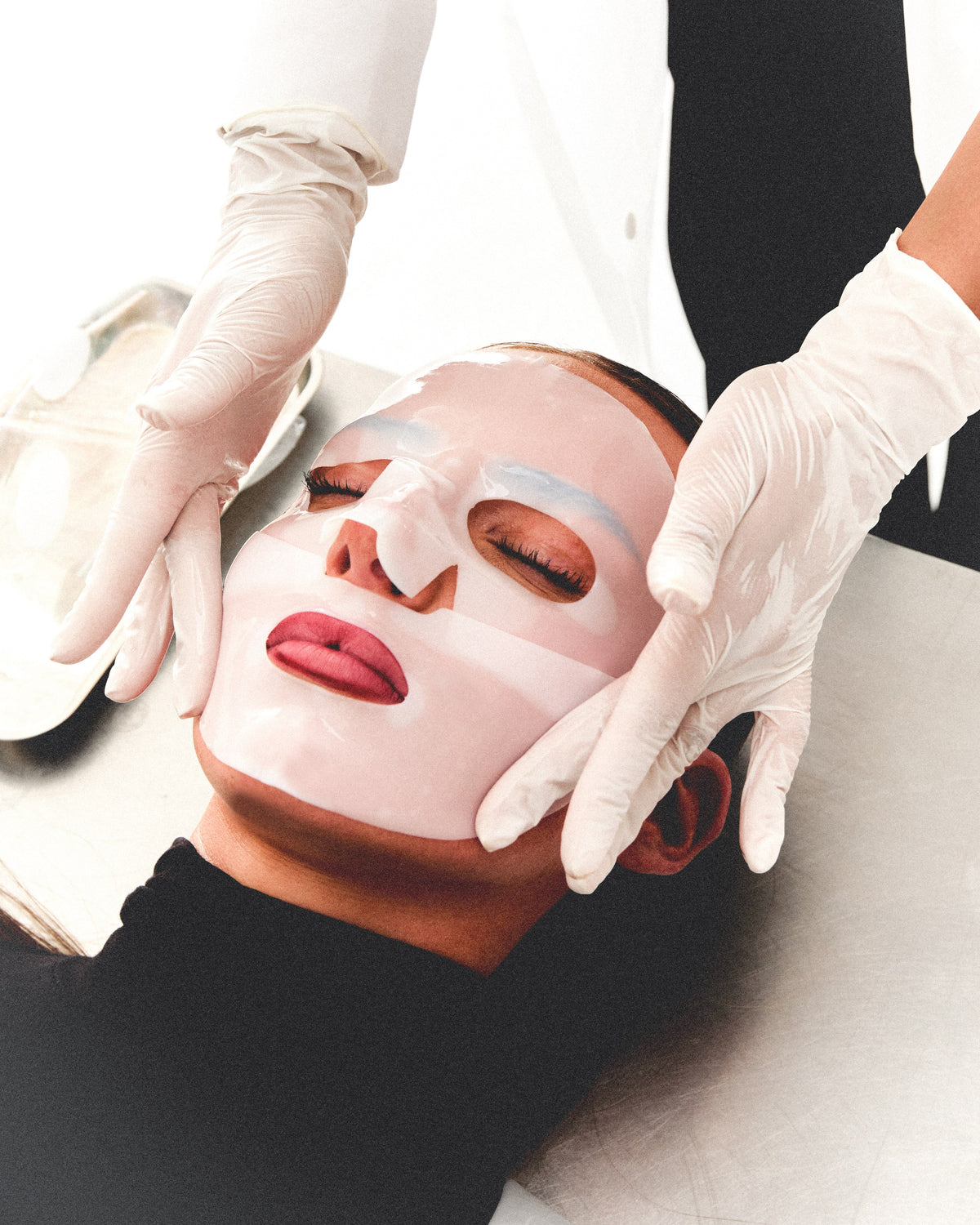 The Peptide Mask being smoothed onto a face by gloved hands