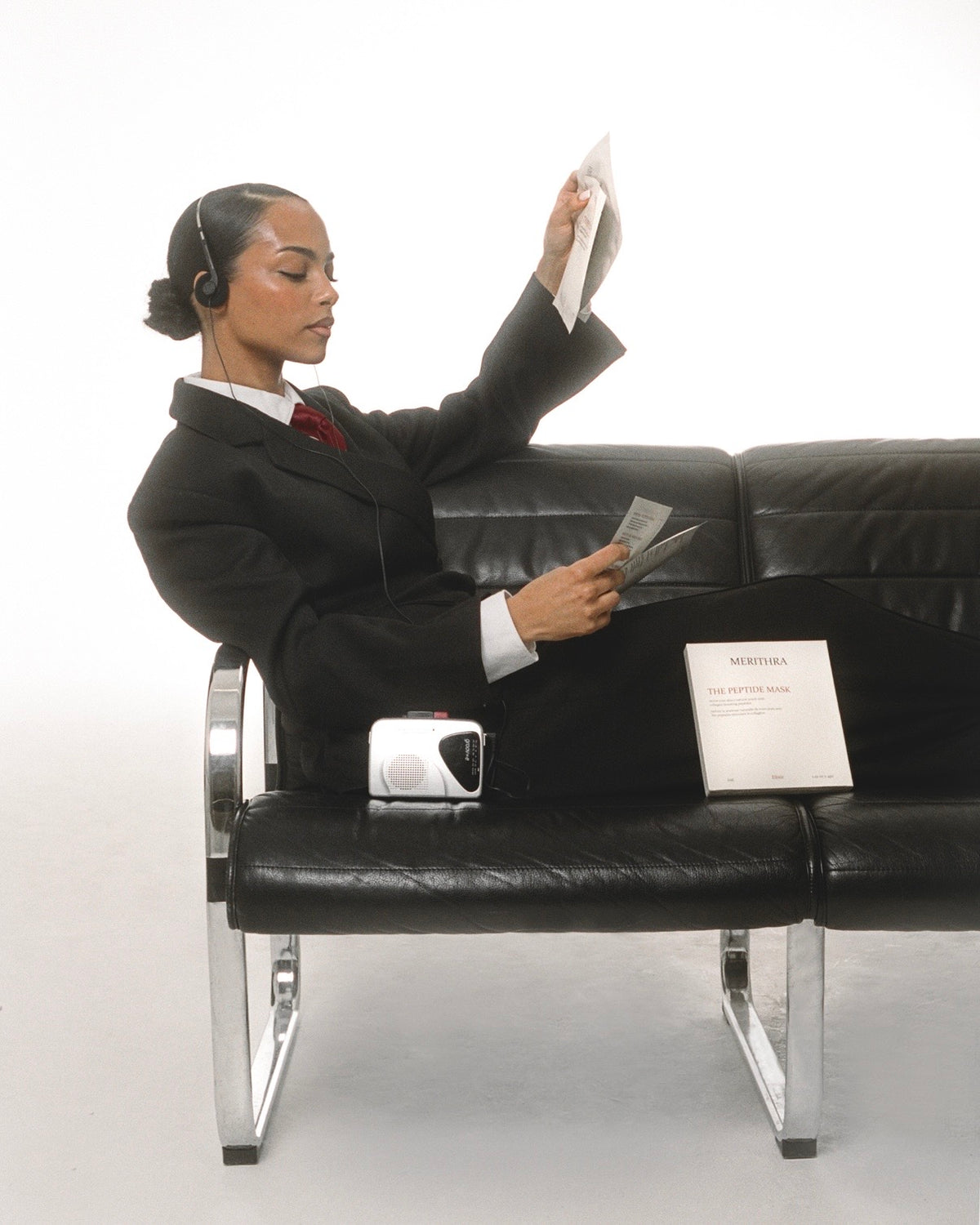 Model on the bench holding a sheet of paper